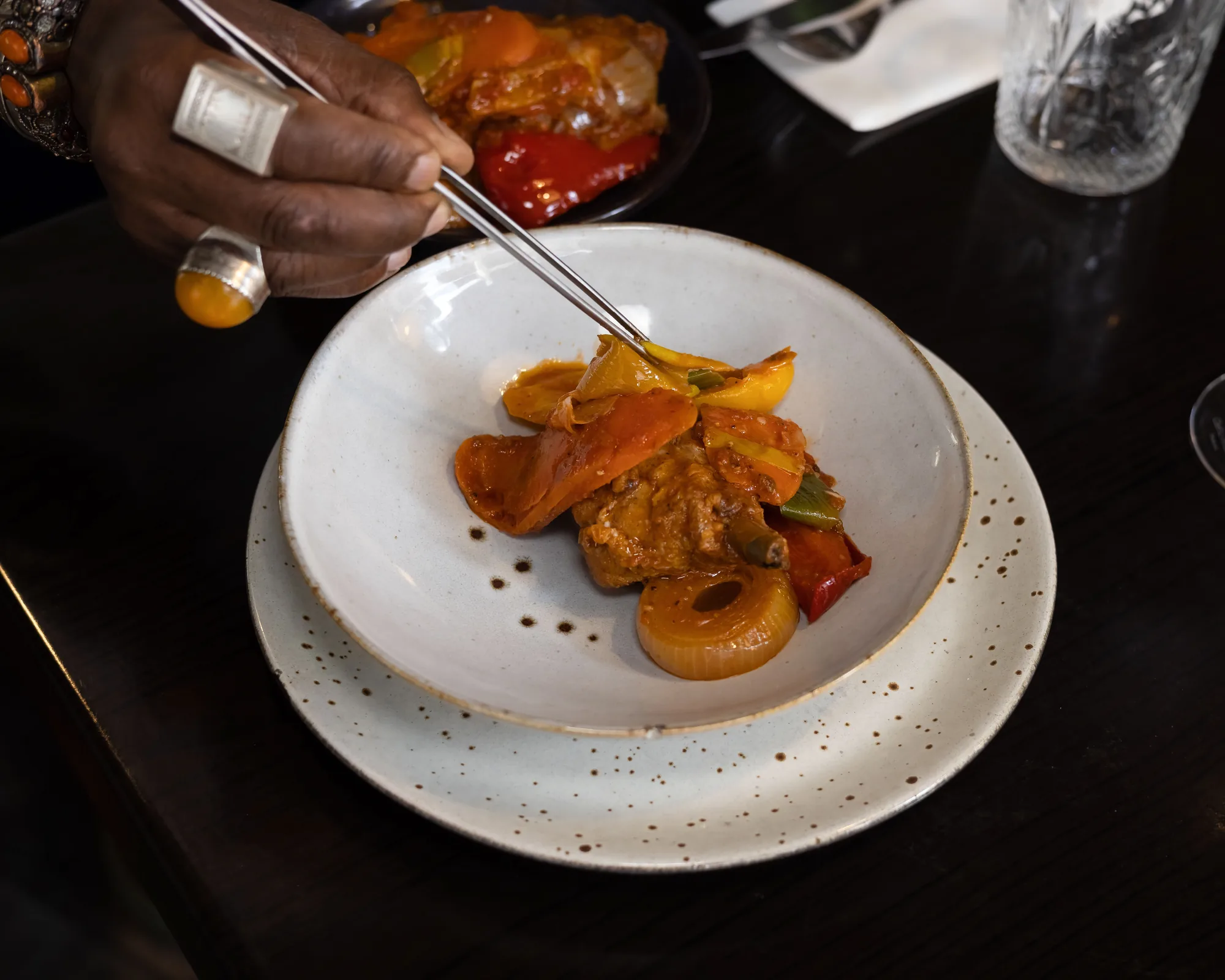 La main du Chef dresse une assiette à la pincette