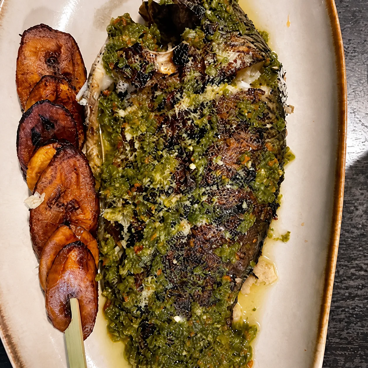 Poisson grillé présenté entier dans l'assiette