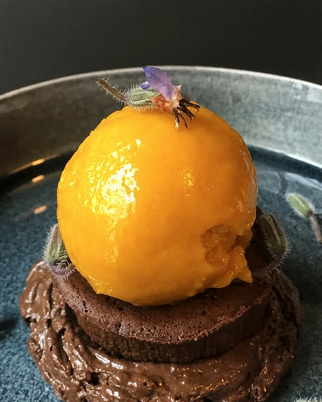 Fondant au chocolat surmonté d'une boule glacée à la mangue